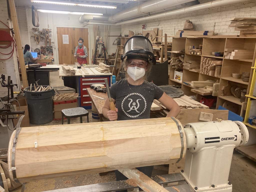 In Tess\' first semester as a professor of Electrical Engineering and Computer Science, she decided to make her own desk. Shown here, she is turning giant wooden tubes for desk leg parts.