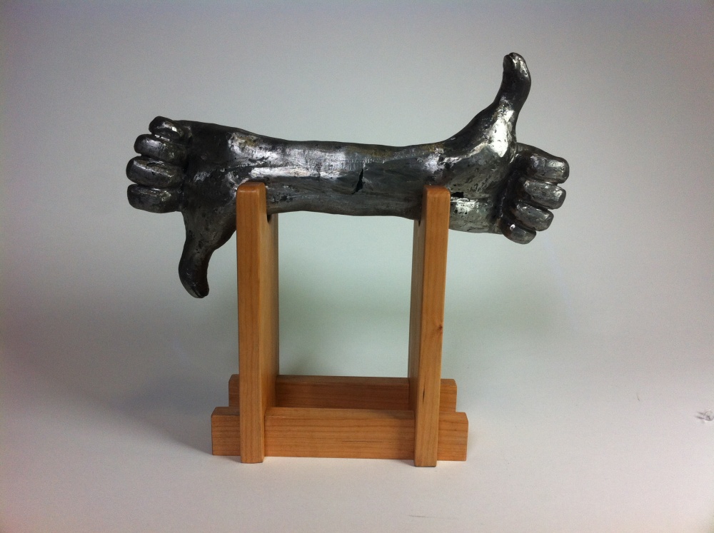 Cast iron hand sculpture and wooden base. This object is meant to give constant positive reinforcement while lifting weights. 